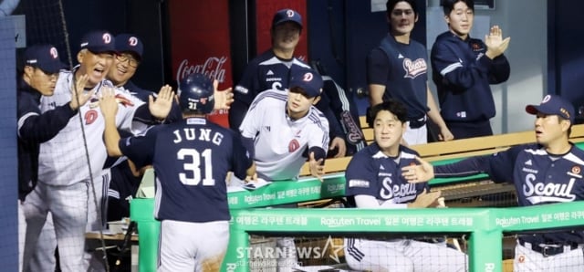 두산 조성환 감독이 30일 잠실야구장에서 열리는 2025KBO리그 LG트윈스와 두산베어스 경기에서 득점한 선수와 자축하고 있다. /사진=강영조 선임기자