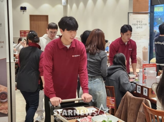 황준서(가운데)가 칼국수 팬미팅에서 서빙을 하고 있다. /사진=안호근 기자