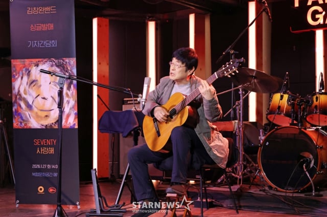 가수 김창완이 27일 오후 서울 종로구 팡타캐라지에서 진행된 싱글 'Seventy' 발매 기자간담회에서 참석자들에게 노래선물을 하고 있다. 이번 싱글에는 'Seventy'와 유쾌한 정서의 팝록 '사랑해'가 수록됐다. /2026.01.27 /사진=이동훈 photoguy@