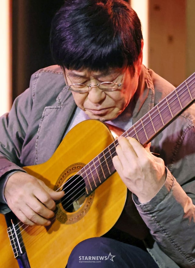 가수 김창완이 27일 오후 서울 종로구 팡타캐라지에서 진행된 싱글 'Seventy' 발매 기자간담회에서 참석자들에게 노래선물을 하고 있다. 이번 싱글에는 'Seventy'와 유쾌한 정서의 팝록 '사랑해'가 수록됐다. /2026.01.27 /사진=이동훈 photoguy@