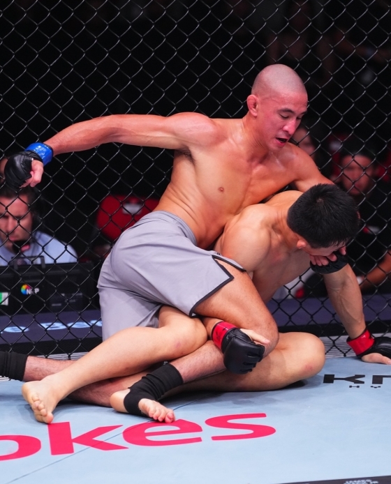 キム·サンウク(右)が1日(韓国時間)、オーストラリア·シドニーのクドスバンクアリーナで開かれた「UFC325:ボルカノフスキーvsロペス2」アンダーカードROAD TO UFC(RTU)シーズン4ライト級決勝戦でドーム·マルファンにバックポジションを許し苦戦している。 /写真=UFC公式ソーシャル·ネットワーキング·サービス(SNS)