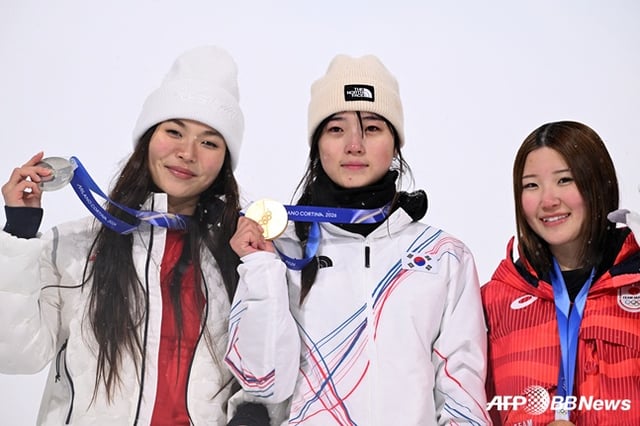스노보드 최가온(가운데)이 13일 이탈리아 리비뇨 스노파크에서 열린 2026 밀라노·코르티나담페초 동계올림픽 스노보드 여자 하프파이프 결선에서 90.25점으로 88.00점의 클로이 김(미국·왼쪽)을 제치고 시상대에 올라 포즈를 취하고 있다. /AFPBBNews=뉴스1