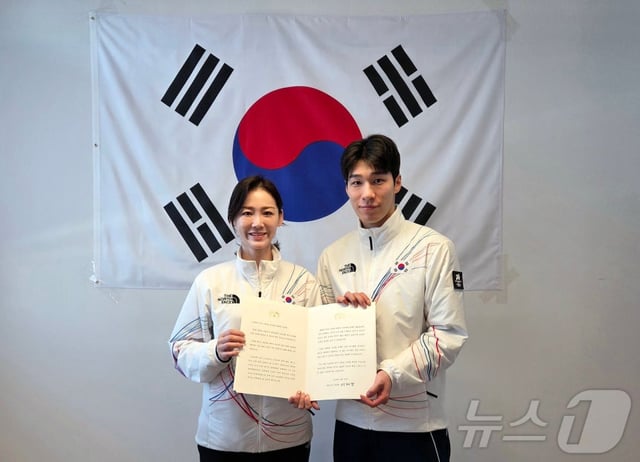 황대헌(오른쪽)이 15일(한국시간) 이탈리아 밀라노에서 이수경 선수단장에게 이재명 대통령 축전을 받은 뒤 기념 촬영을 하고 있다. 왼쪽부터 2026 밀라노·코르티나담페초 동계올림픽 대한민국 선수단 단장 이수경, 쇼트트랙 남자 1500m 은메달리스트 황대헌. /사진=뉴스1 제공