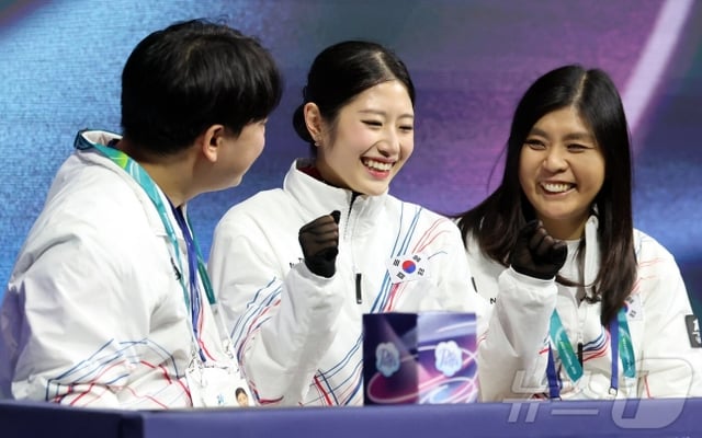 이해인(가운데)이 키스 앤드 크라이 존에서 점수를 확인한 뒤에 코치진들과 함께 환하게 웃고 있다. /사진=뉴스1