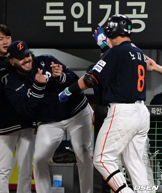 노시환(오른쪽)이 홈런을 치고 더그아웃에 들어오자 하트를 날리는 폰세(왼쪽).