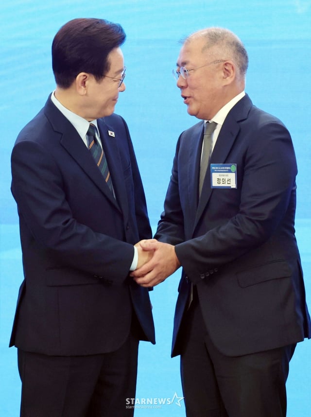 [群山=ニューシス]チェ·ドンジュン記者=イ·ジェミョン大統領が27日、全羅北道群山のセマングムコンベンションセンターで開かれた「セマングムロボット·水素·AIシティ投資協約式」で記念撮影を終えた後、現代自動車グループのチョン·ウィソン会長と握手している。 （大統領府通信写真記者団）2026.02.27. photocdj@newsis.com /写真=