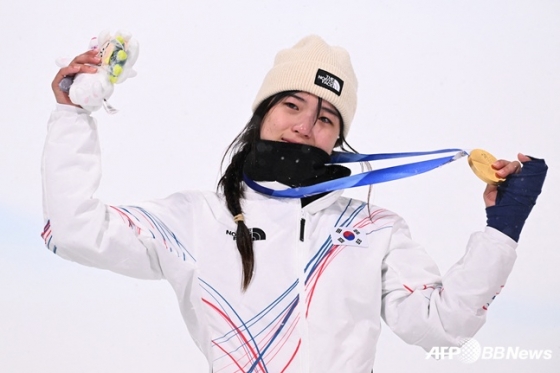 최가온이 지난 2월 13일(현지시간) 이탈리아 리비뇨 스노파크에서 열린 2026 밀라노·코르티나담페초 동계올림픽 스노보드 여자 하프파이프 결선에서 90.25점으로 88.00점의 클로이 김(미국)을 제치고 금메달을 목에 걸고 포즈를 취하고 있다. /AFPBBNews=뉴스1