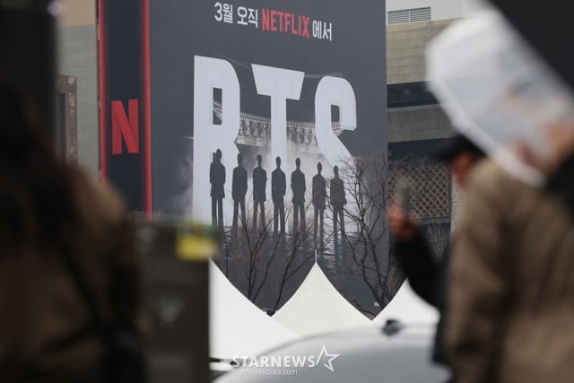 (서울=뉴스1) 오대일 기자 = 방탄소년단(BTS) 완전체 컴백 공연을 사흘 앞둔 18일 서울 광화문광장에서 외국인 팬들이 컴백 공연을 알리는 전광판 광고를 스마트폰으로 촬영하고 있다. 정부는 이날 방탄소년단(BTS) 광화문 공연을 앞두고 19일 0시부터 21일 밤 12시까지 종로구와 중구 등 도심 일대 테러경보를 기존 '관심'에서 '주의'로 상향 발령한다고 밝혔다. 2026.3.18/뉴스1 Copyright © 뉴스1. All rights reserved. 무단 전재 및 재배포, AI학습 이용 금지. /사진=(서울=뉴스1) 오대일 기자