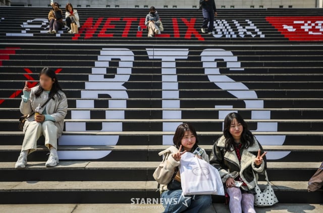 [서울=뉴시스] 정병혁 기자 = 방탄소년단(BTS)의 서울 광화문광장 컴백 공연을 앞둔 17일 서울 종로구 세종문화회관 계단을 찾은 일본인 팬들이 방탄소년단 랩핑 앞에서 사진을 찍고 있다. 2026.03.17. jhope@newsis.com /사진=정병혁