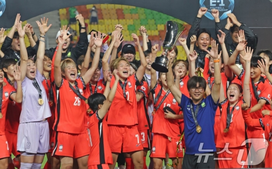2025年東アジアサッカー連盟(EAFF)E-1チャンピオンシップ(東アジアカップ)優勝セレモニーを行う大韓民国女子国家代表チーム。 優勝トロフィーを手に笑顔を見せるシン·サンウ監督(青の上着)。 /写真=ニュース1