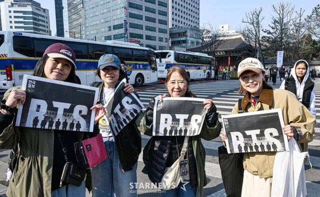 [서울=뉴시스] 그룹 방탄소년단(BTS) 컴백 공연을 앞둔 21일 서울 광화문 일대에서 일본인 관광객들이 한국일보가 발행한 BTS 특별판을 들어 보이고 있다. (사진=한국일보 제공) 2026.03.21. photo@newsis.com *재판매 및 DB 금지 /사진=