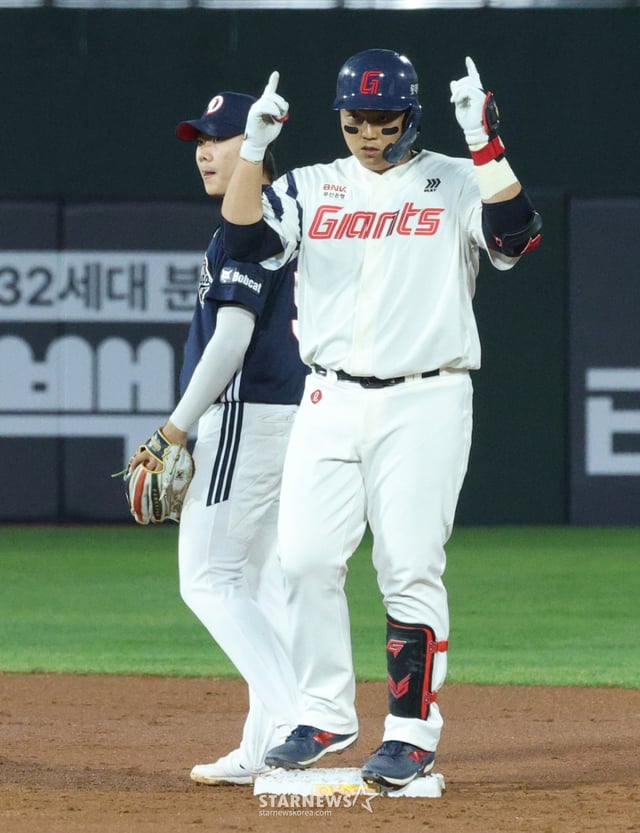 The 2026 Shinhan SOL KBO League game between Lotte Giants and Doosan Bears was held at Busan Sajik Baseball Stadium on the 23rd. Lotte's Han Dong-hee hits a two-run double to left field in the bottom of the 3rd inning with two outs, reaches base, and performs a ceremony. /Photo=Chief correspondent Kim Jin-kyung