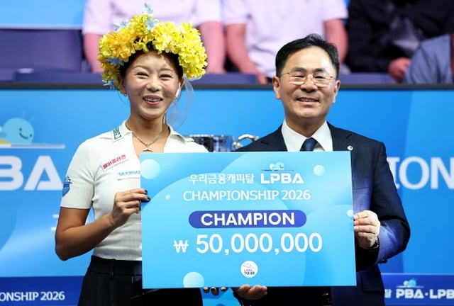 김가영(왼쪽)이 23일 경기도 고양시 '고양 킨텍스 PBA 스타디움'에서 열린 프로당구 2026-2027시즌 개막 투어 '우리금융캐피탈 PBA-LPBA 챔피언십' LPBA 결승전에서 우승한 뒤 기동호 우리금융캐피탈 대표이사와 기념 촬영을 하고 있다. /사진=PBA 투어 제공
