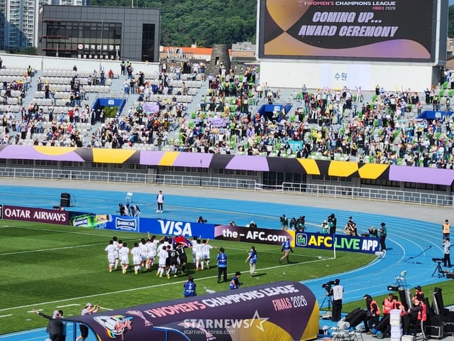 私の故郷の女子サッカー団(左下)が人共旗を持って走ると、共同応援団(右)が歓呼している。 /写真=朴コンド記者