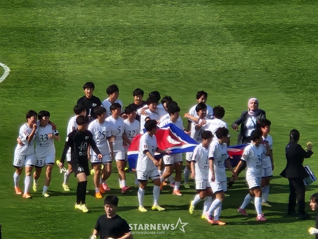 優勝直後、人工旗を持って競技場を回る私の故郷の女子サッカー団。 /写真=朴コンド記者