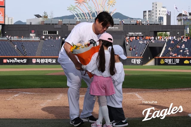 류현진이 24일 통산 200승 기념식에서 자녀로부터 꽃다발을 받고 있다. /사진=한화 이글스