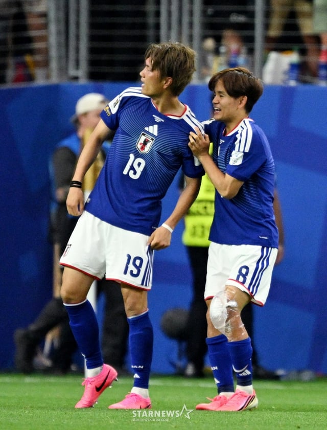 Takefusa Kubo of the Japan national football team (right), who was substituted during the first match of the 2026 FIFA World Cup North, Central America and Caribbean Group F against the Netherlands at the Dallas Stadium in Japan on the 15th, is seen congratulating Goki Ogawa, who scored a dramatic equalizer, while icing his left knee. /Photo=Reuters=NEWS1