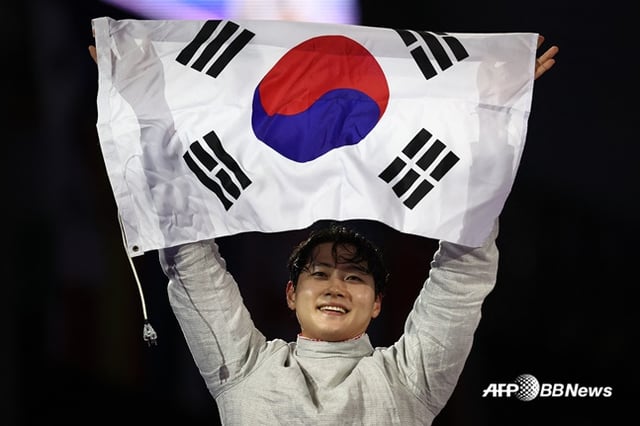 오상욱이 지난 2024년 8월 프랑스 파리 그랑 팔레에서 열린 2024 파리 올림픽 펜싱 남자 사브르 개인전 결승에서 금메달을 따낸 뒤 태극기를 들며 기뻐하고 있다. /AFPBBNews=뉴스1