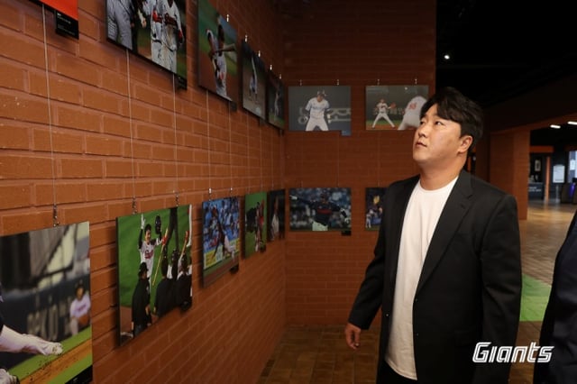 정훈이 26일 부산 LG전을 앞두고 열린 자신의 은퇴식에서 개최된 현역 시절 사진을 관람하고 있다. /사진=롯데 자이언츠 제공