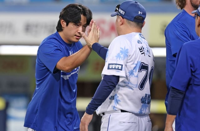 ヤン·チャンソプとパク·ジンマン監督が16日の試合直後、ハイタッチをしている。 /写真=三星ライオンズ