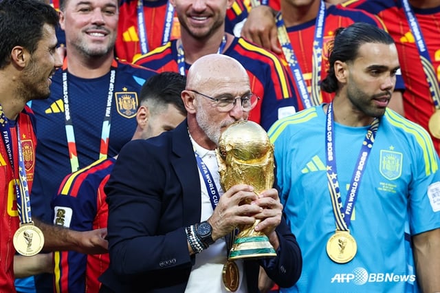 ルイス·デ·ラ·プエンテ監督(中央)がW杯優勝カップに口づけをしている。 /AFPBBNews=ニュース1
