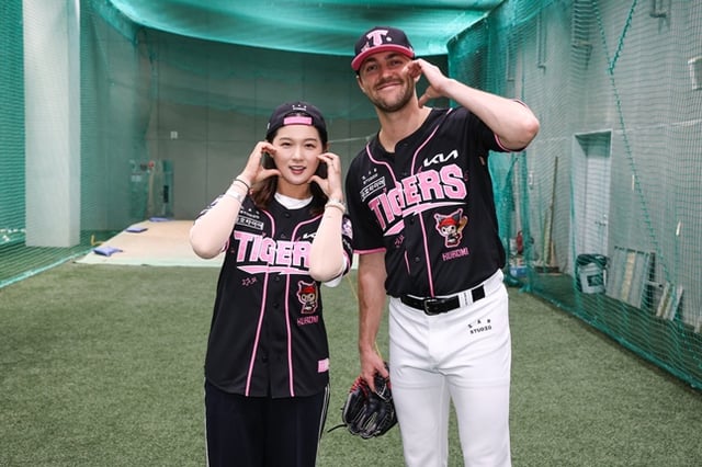 Professional golfer Park Hyun-kyung (left) receives pitching guidance from James Nail before serving as the ceremonial first pitcher for the game between KIA Tigers and Hanwha Eagles on the 21st, and poses for a commemorative photo together. /Photo=KIA Tigers provided