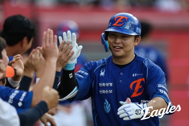 Hanwha Eagles' Moon Hyun-bin flashes a bright smile after hitting a two-run home run in the bottom of the third inning during the visiting game against the KIA Tigers at Gwangju-Kia Champions Field on the 23rd, celebrating with teammates by hugging Haifa Eve. /Photo=Hanwha Eagles provided