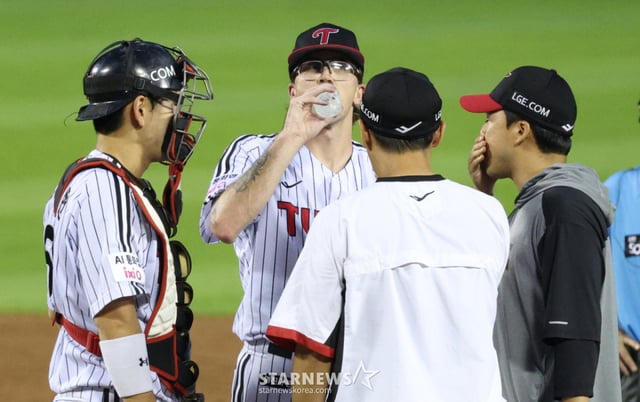 Lachlan Wells, starting pitcher quốc tế của LG Twins (giữa), đang bị lung lay ở hiệp 1 trong trận đấu tại nhà với NC Dinos của 2026 Shinhan SOL KBO League vào ngày 23 tháng 7, và huấn luyện viên ném bóng đang lên ụ ném bóng để trấn tĩnh anh ta. /Ảnh=phóng viên trưởng Kim Jin-kyung