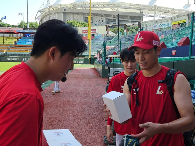 SSG 랜더스 신인 투수 김민준(왼쪽)이 7월 24일 경기를 앞두고 선수단에게 직접 마련한 간식 박스를 전달하고 있다. /사진=SSG 랜더스 제공