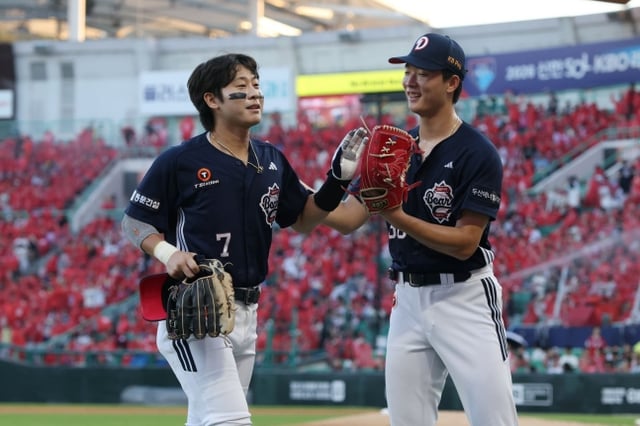 斗山(トゥサン)ベアーズのチェ·ミンソク(右)が30日、仁川(インチョン)SSGランダースフィールドで行われたSSGランダースと2026新韓(シンハン)SOLKBOリーグ訪問試合で、朴賛浩の好守備でイニングをうまく防ぎ、ハイタッチをしている。 /写真=斗山ベアーズ提供
