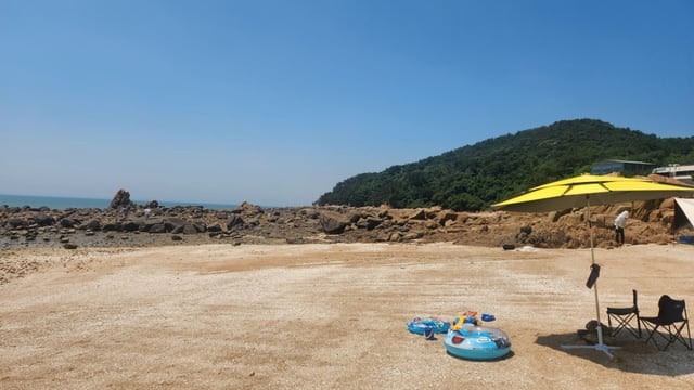 At Seonyeobawi Beach, walking along the fine white sandy beach, rocky shores, and sea pine forests makes for an excellent stroll.