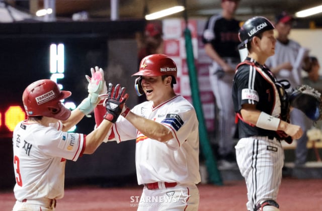 SSG Landers' Kim Jae-hwan (center) celebrates with Jung Jun-jae and Haifa Eve after hitting a three-run home run over the fence in the bottom of the seventh inning with two outs and runners on first and second base against LG Twins at the 2026 Shinhan SOL KBO League game held at Incheon SSG Landers Field on the 4th. /Photo=Senior reporter Kang Young-jo