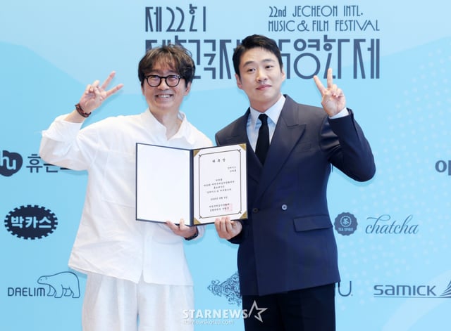 장항준 감독(집행위원장), 배우 안재홍이 6일 서울 중구 커뮤니티하우스 마실에서 진행된 '제22회 제천국제음악영화제' 기자회견에서 홍보대사 위촉장을 전달한 뒤 포즈를 취하고 있다./2026.08.06 /사진=김휘선 hwijpg@