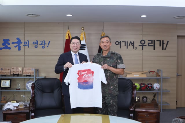 Head Lee Sang-hyun (left) presents a Team Korea T-shirt to Chief of Staff Kim Young-il. /Photo=Korean Olympic Committee provided