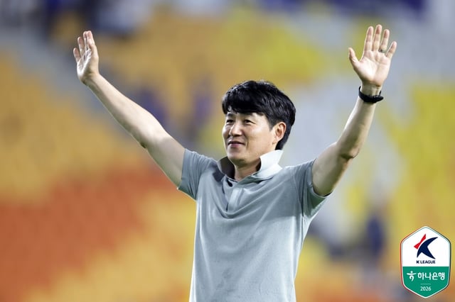 SuwonFC manager Park Geon-ha is showing off his trademark 'collar ceremony' from his playing days to the Suwon Samsung supporters. /Photo=Korea Professional Football League