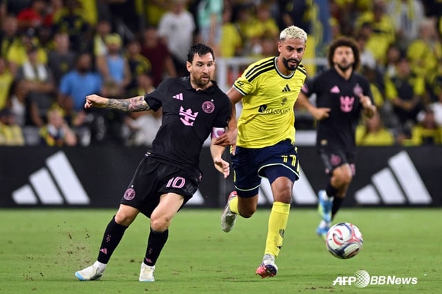 Lionel Messi (left) is seen competing for the ball. /AFPBBNews=NEWS1