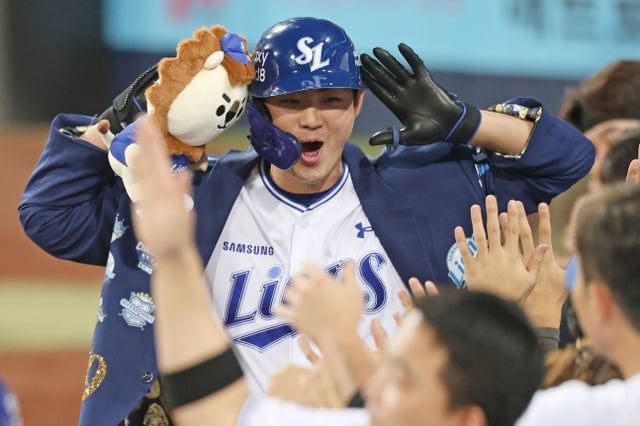 Samsung Lions' Koo Ja-wook hits a go-ahead two-run home run in the bottom of the first inning against the Hanwha Eagles on the 15th and performs a ceremony amidst the welcome of his teammates. /Photo=Samsung Lions provided