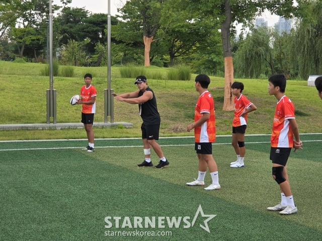 OK 읏맨 럭비단 양지융(가운데 검은 옷)이  지난15일 인천광역시 서구 청라동에 위치한 하나글로벌캠퍼스에서 열린'제3회 OK 읏맨 럭비 아카데미'에서 아이들을 지도하고 있다. /사진=OK 읏맨 럭비단 제공