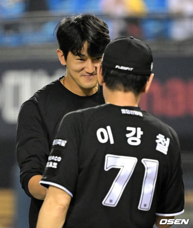 Go Young-pyo (izquierda), quien alcanzó las 10 victorias en la temporada, y el entrenador Lee Kang-cheol saludando con un pañuelo Haifa.