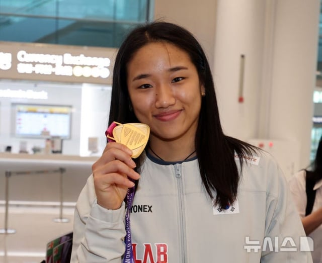  인도 뉴델리에서 열린 세계배드민턴연맹(BWF) 세계선수권대회 여자 단식에서 금메달을 차지한 안세영이 25일 오전 인천공항을 통해 귀국해 취재진에게 메달을 들어보이고 있다. /사진=뉴시스