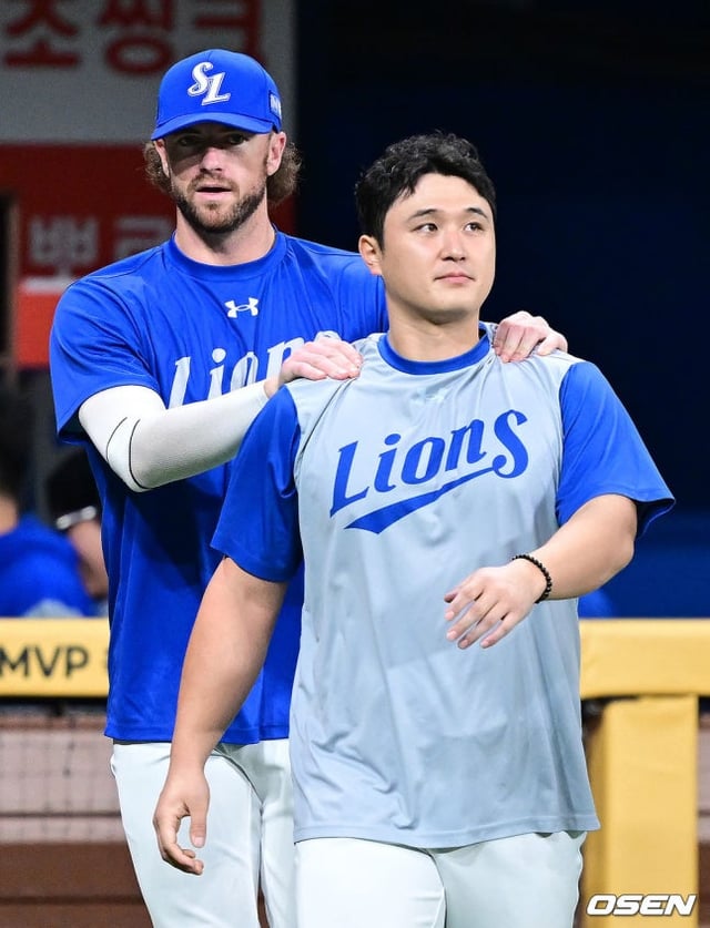 Fedex masajea los hombros de Choi Won-tae después de finalizar el partido del día 26.