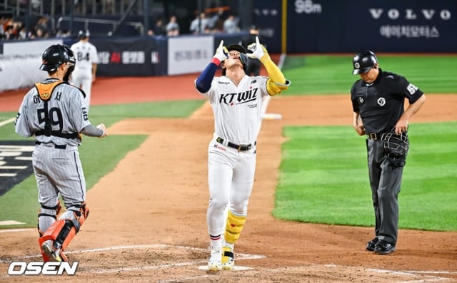 KT安贤民（中）在3日对阵韩华的比赛中于第3局击出连续打击本垒打后跑回本垒并做出庆祝动作。/图片=OSEN