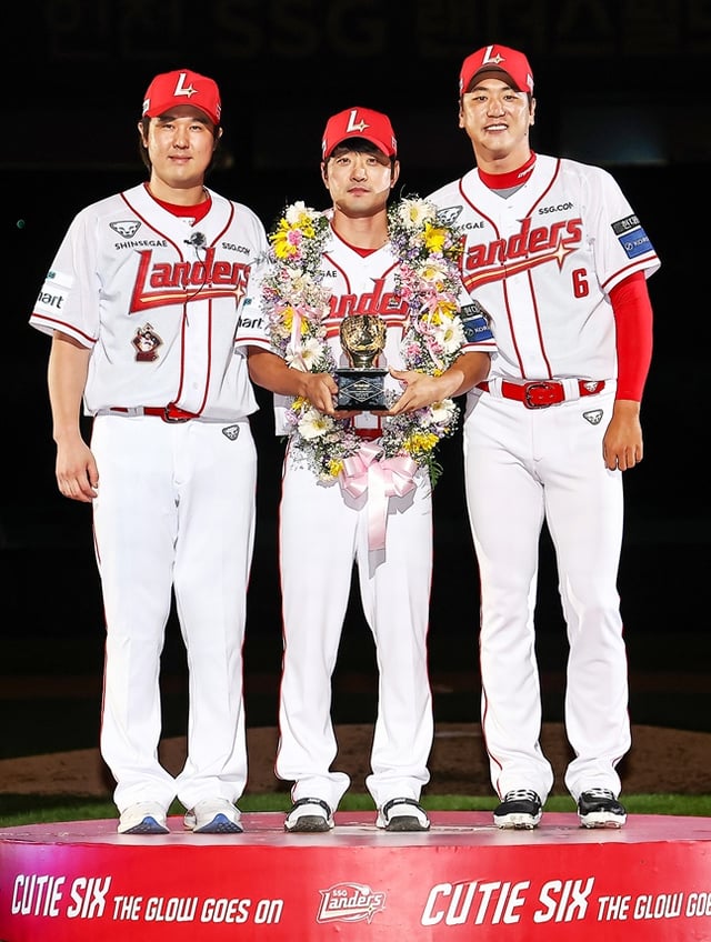 SSGランダースの金ソンヒョン（中央）が5日、仁川（インチョン）SSGランダースフィールドで斗山（トゥサン）ベアーズ戦終了後に行われた引退式で、崔廷（チェ·ジョン、左）、金広鉉（キム·グァンヒョン）から引退記念の黄金グローブをプレゼントされ、記念撮影をしている。 /写真=SSGランダース提供