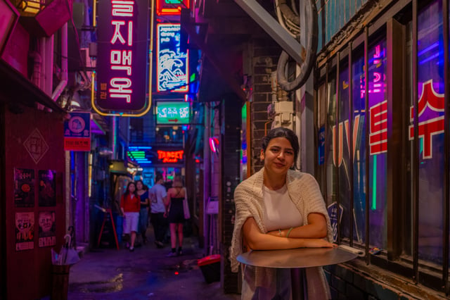 Travelers capturing snapshots from neon signs and storefronts