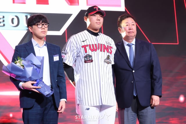 El lanzador del Instituto Secundario Inchang, Yoon Ye-seong (en el centro), fue seleccionado en la décima posición general de la primera ronda del Draft de Novatos KBO 2027, que se celebró el día 21 en el World Crystal Ballroom del Hotel Lotte en el distrito Songpa-gu de Seúl. Yoon subió al escenario junto a su hermano y posó para una fotografía conmemorativa con el director Cha Myeong-seok (a la derecha). /Foto=corresponsal jefe Kim Jin-kyung