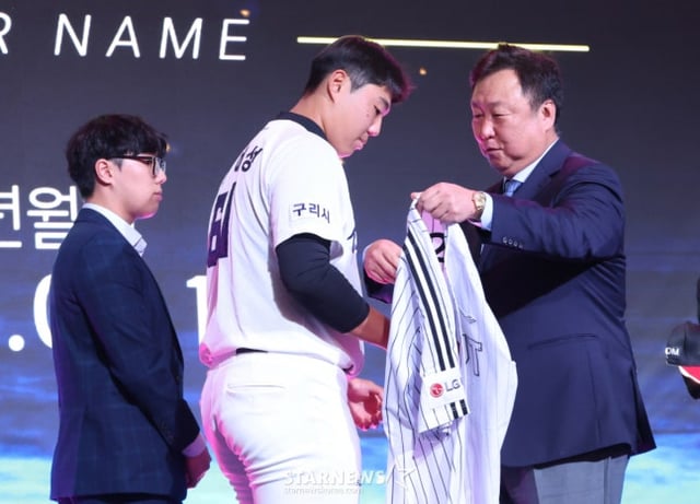 차명석(오른쪽) LG 단장이 21일 KBO 신인드래프트에서 1라운드로 지명한 인창고 투수 윤예성에게 유니폼을 입히고 있다. /사진=김진경 대기자