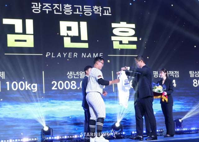 '2027 KBO 신인 드래프트'가 21일 서울 송파구 롯데호텔 월드 크리스탈볼룸에서 열렸다. 김민훈(광주진흥고)이 전체 7순위로 삼성에 지명된 후 이종열 단장의 도음으로 삼성 유니폼을 입고 있다. /사진=김진경 대기자