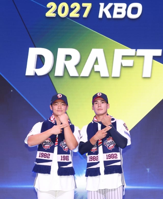 설재민(왼쪽)과 김지우가 21일 서울 롯데호텔 월드 크리스탈볼룸에서 열린 2027 KBO 신인드래프트에서 1,2라운드에서 지명을 받은 뒤 구단이 전달한 유니폼을 입고 포즈를 취하고 있다. /사진=두산 베어스 제공