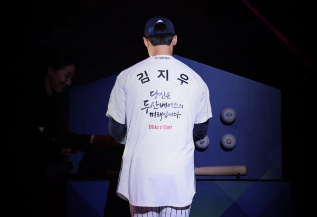 서울고 김지우가 21일 서울 롯데호텔 월드 크리스탈볼룸에서 열린 2027 KBO 신인드래프트에서 1라운드 2순위 지명을 받은 뒤 특별한 메시지가 새겨진 유니폼을 입고 있다. /사진=두산 베어스 제공
