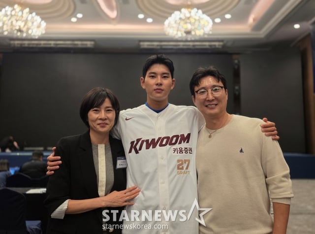 キウムのハ·ヒョンスン(中央)が21日、ソウルロッテホテルワールドクリスタルボールルームで開かれた2027KBO新人ドラフトでキウムの全体1位指名を受けた後、父親のハ·チュンス、母親のシン·ミョンヒ氏と写真撮影に応じた。 /写真=キム·ドンユン記者